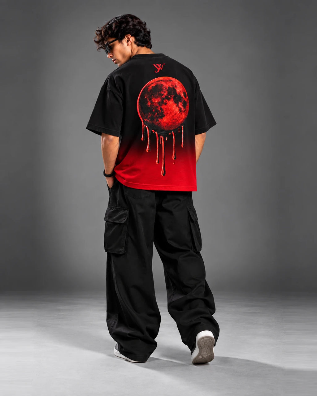 Editorial streetwear shot of the Blood Moon Black Ombre Tee showing the red moon back graphic