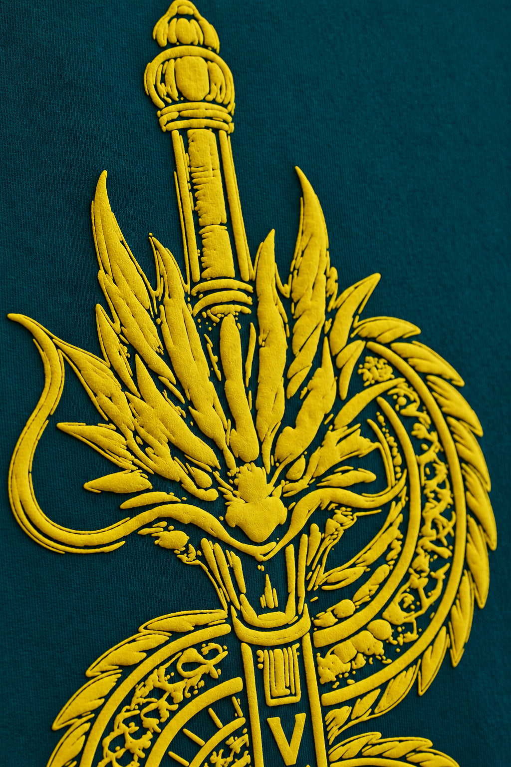 Close-up of the golden dragon and sword graphic on the Teal Dragon Sword T-Shirt fabric