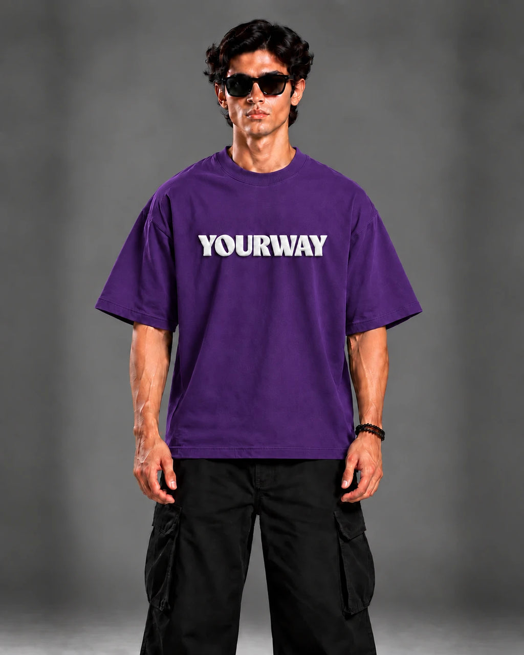 Studio portrait of model wearing the Royal Purple T-Shirt, front view styled with black cargo pants