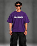 Studio portrait of model wearing the Royal Purple T-Shirt, front view styled with black cargo pants
