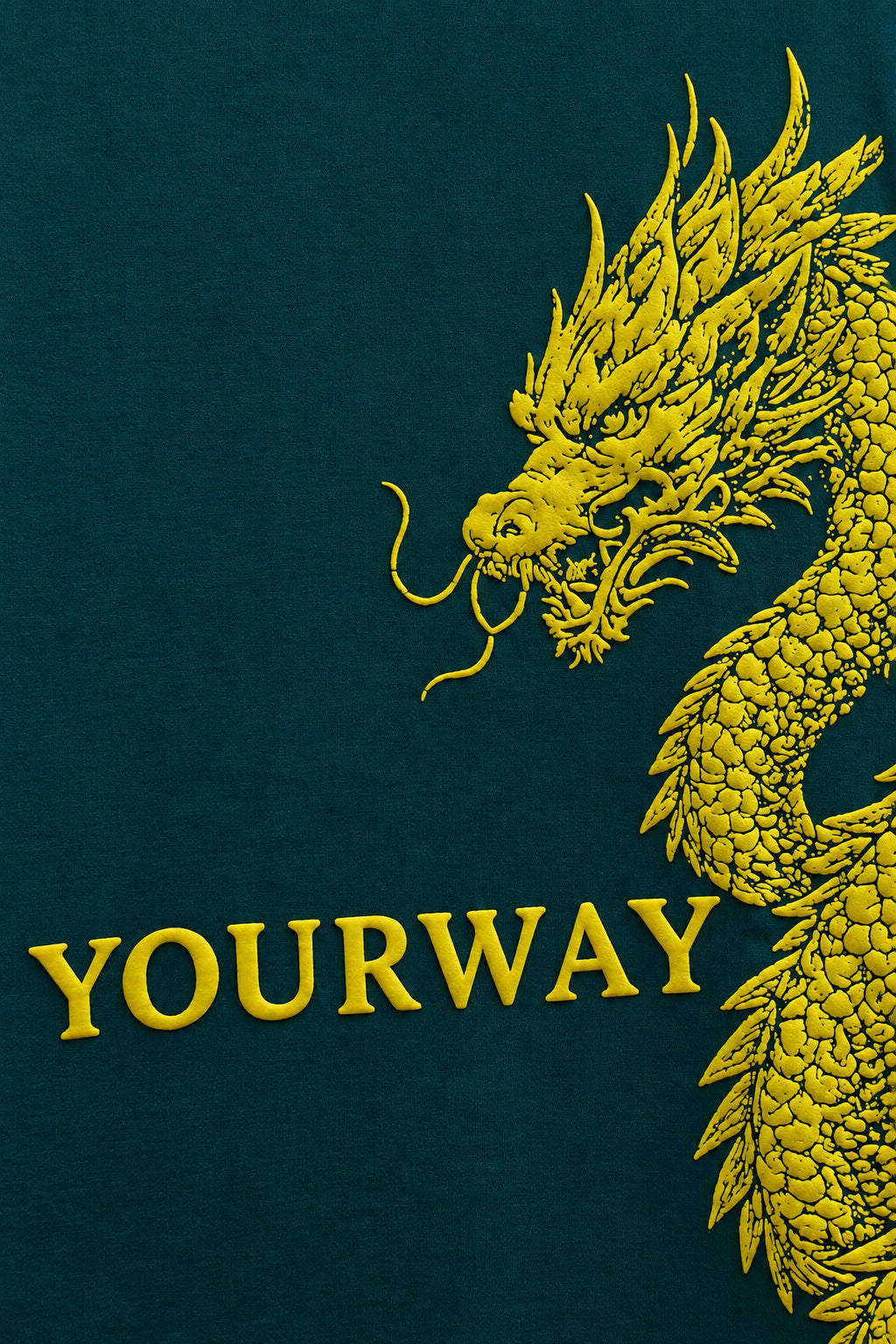 Close-up of the raised golden dragon scale texture on the Teal Dragon Sword T-Shirt
