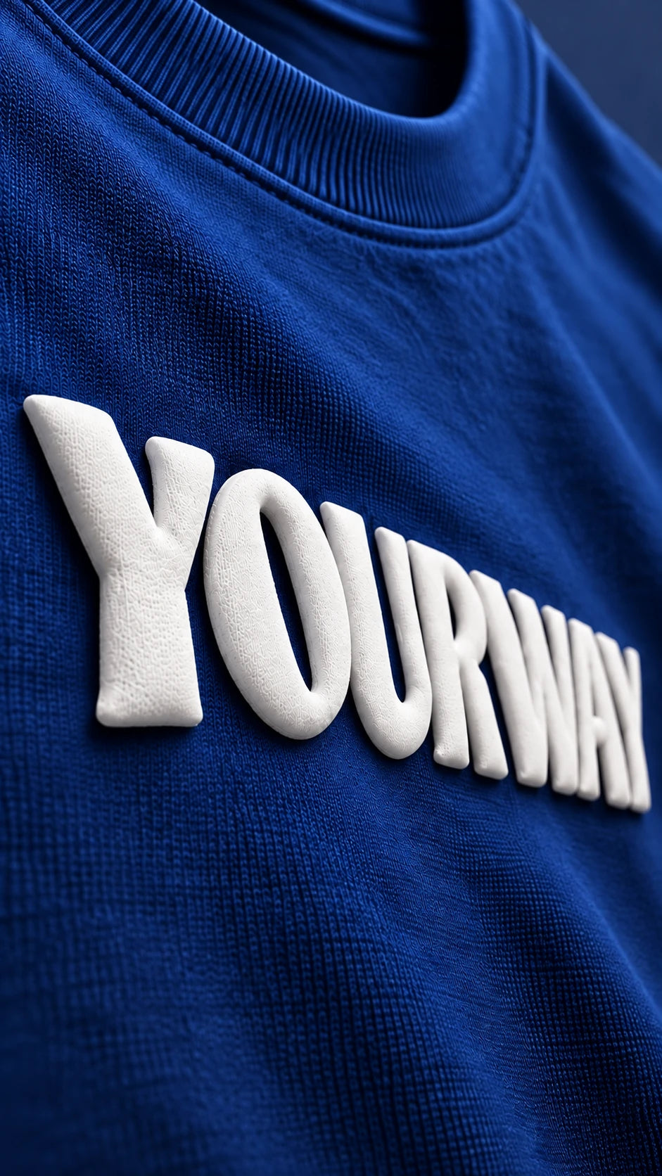Close-up of the raised white YOURWAY puff print wordmark on the Navy Blue T-Shirt