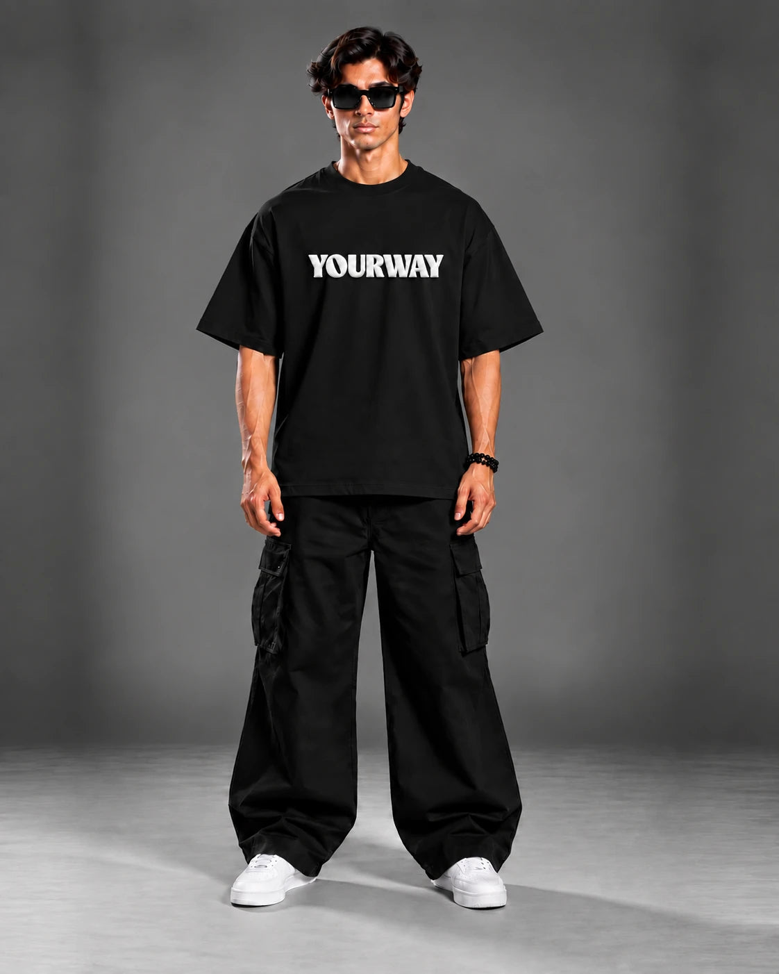 Studio portrait of model wearing the Black T-Shirt, back view with YW monogram print on the collar