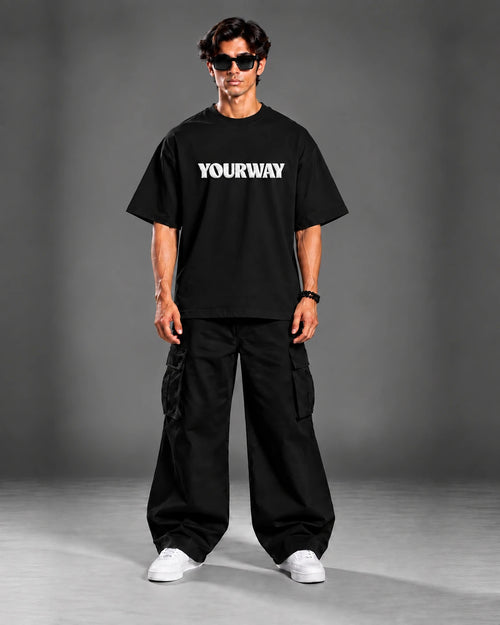 Studio portrait of model wearing the Black T-Shirt, back view with YW monogram print on the collar