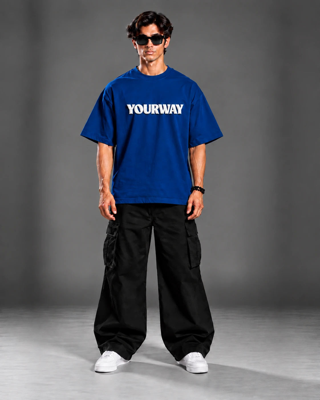 Studio portrait of model wearing the Navy Blue T-Shirt, front view with white YOURWAY puff print wordmark