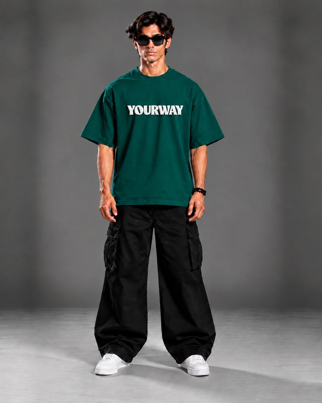 Studio portrait of model wearing the Emerald Green T-Shirt, front view with white YOURWAY puff print wordmark